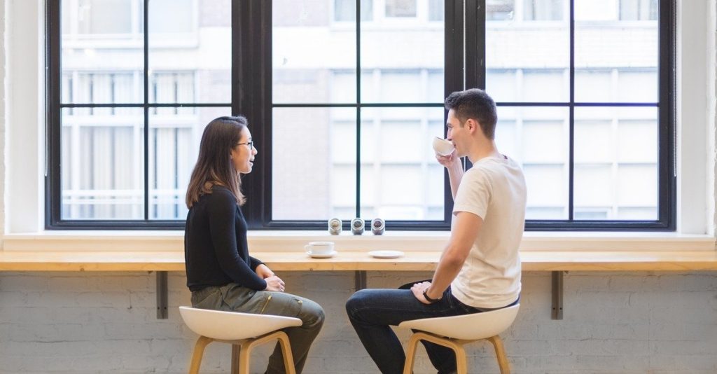 man and woman talking over coffee
