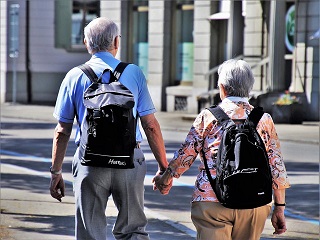 elderly couple traveling holding hands
