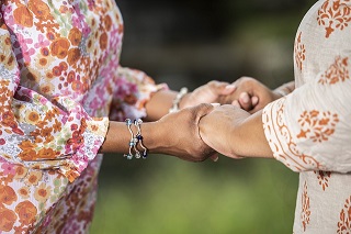 women holding hands facing one another