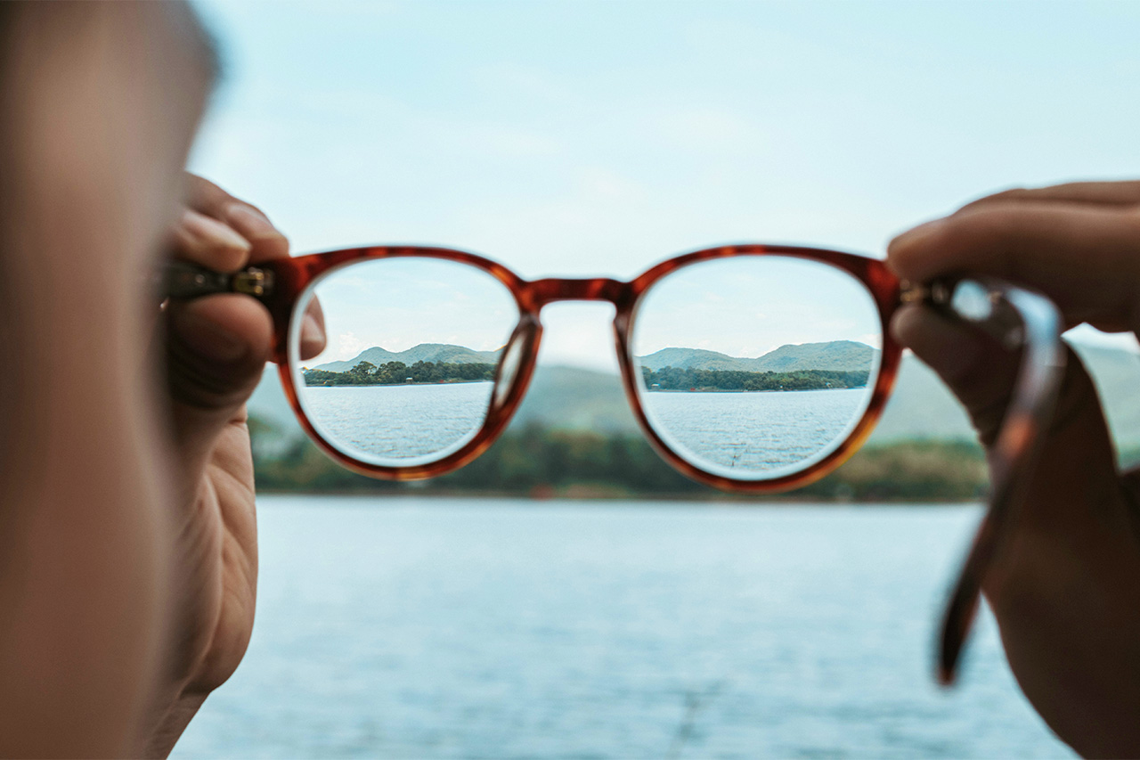 Woman looking through glasses symbolizing gaining perspective and clarity as a result of executive-life coaching