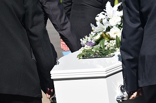 men carrying white casket with flowers
