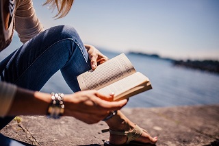 woman reading by water