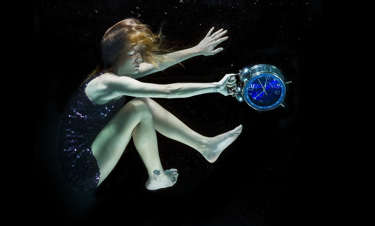 woman underwater with clock procrastination