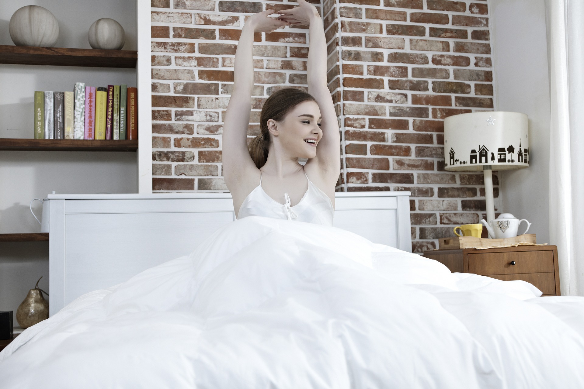 woman waking up stretching bedroom